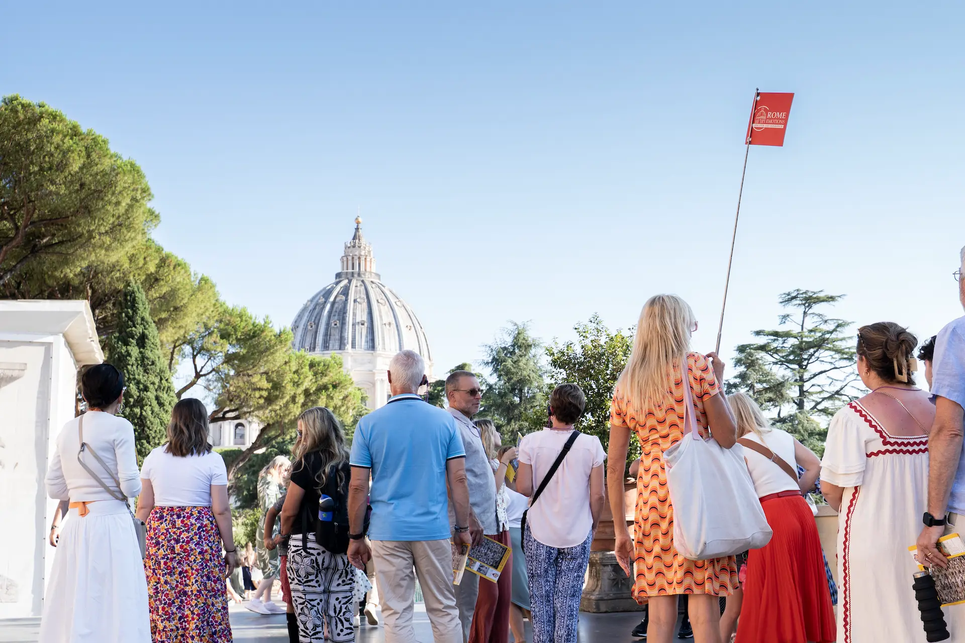 Guided tour group with St Peter’s Basilica dome in the background