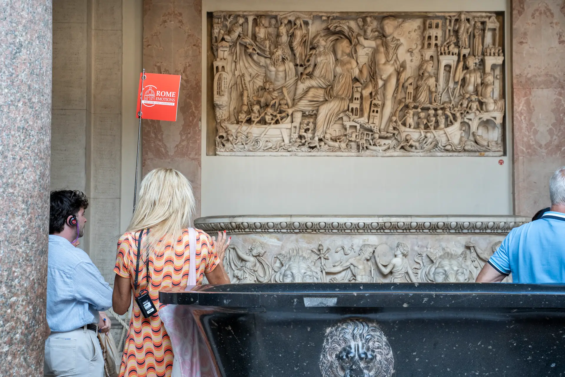 Tour guide explaining a classical sculpture inside the Vatican Museums