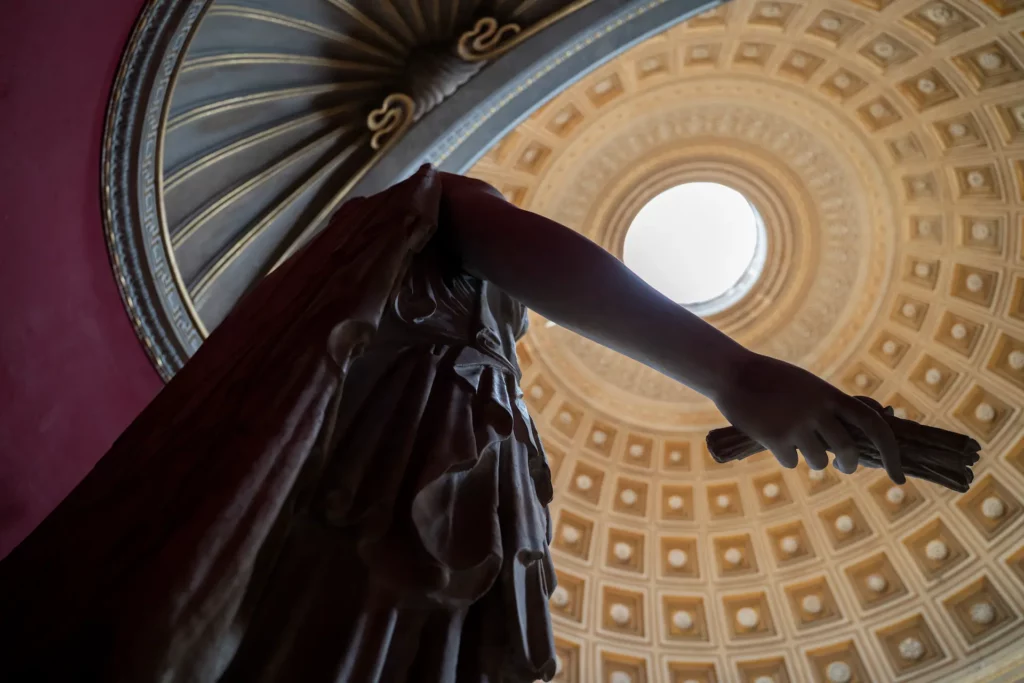 Classical statue under a domed ceiling inside the Vatican Museums