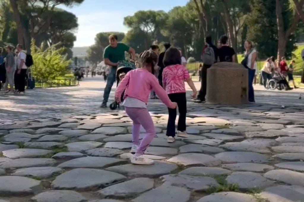 Children walking along the ancient way leading to Colosseum during a family tour in Rome