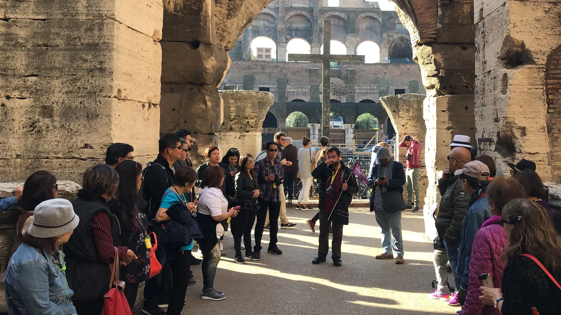 Tour group listening to a guide inside the Colosseum