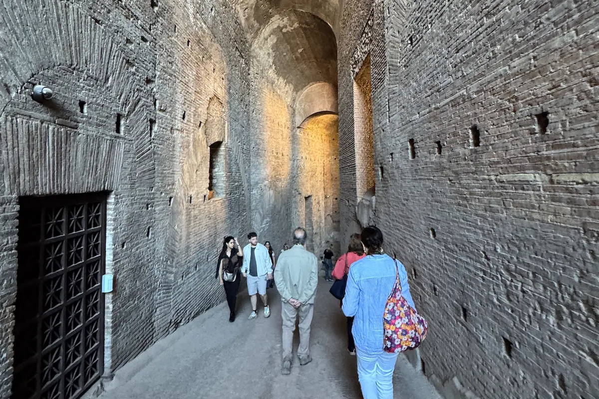 Visitors walking inside the ancient corridors of the Colosseum in Rome